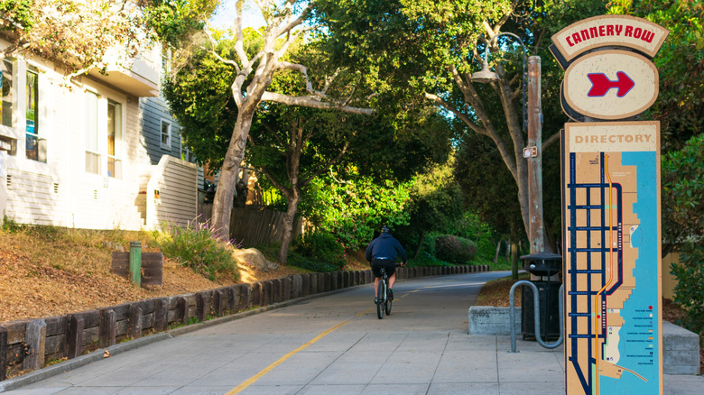 Man cycling past directional sign on Monterey Bay Coastal Recreation Trail