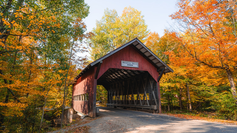 Brookdale Covered Bridge surrounded by fall foliage in Stowe, Vermont, during autumn