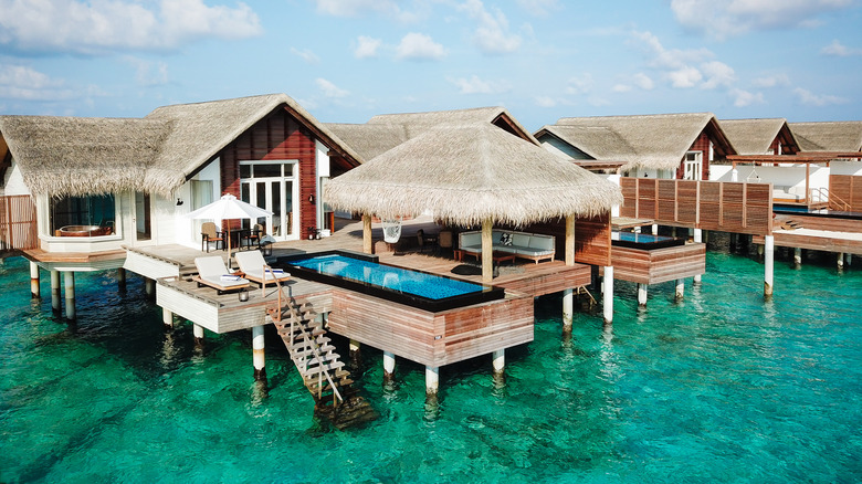 Maldives Water Villa Bungalow Overwater with Pool and step ladder reaching down towards a turquoise lagoon.