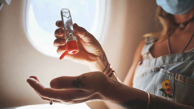 Person using hand sanitizer on plane