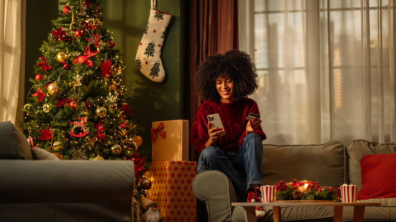 Woman on phone with Christmas decor