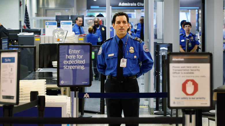 A TSA agent waits for passengers to use the TSA PreCheck lane