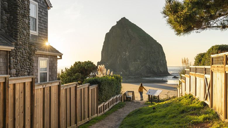 Woman looking at Haystack Rock by house in residential lane