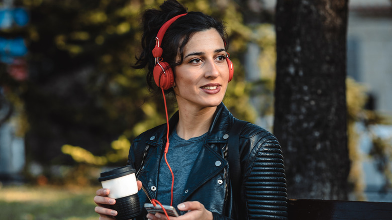 A woman enjoying music with red wired headphones