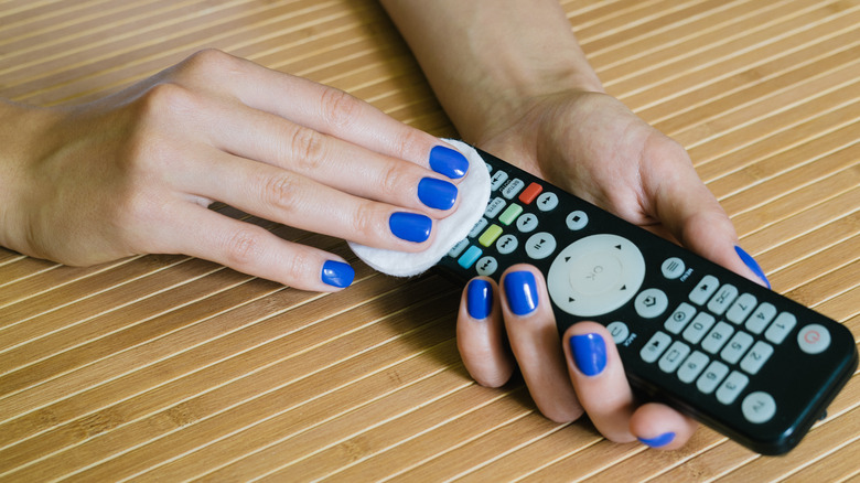 Hands cleaning a remote