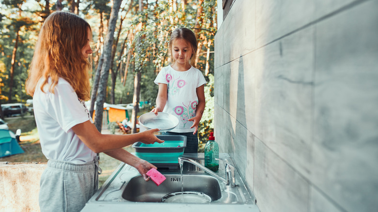 Woman washing dishes outdoors