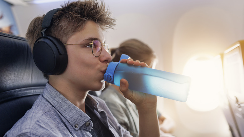 boy drinking water on flight