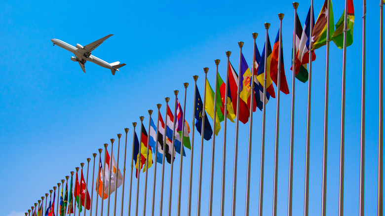 Airplane flying over flags