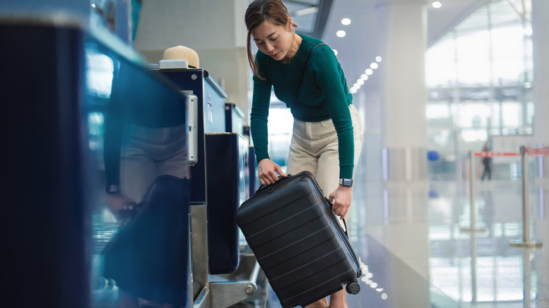 traveler checking their luggage at the airline counter