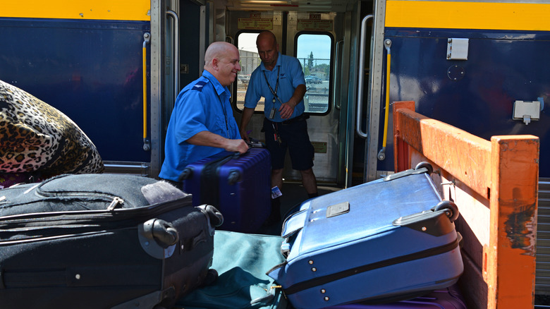 Amtrak crew members transport checked luggage