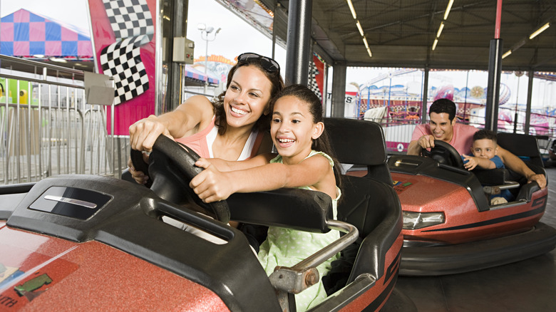 Family of four in two bumper cars at a theme park