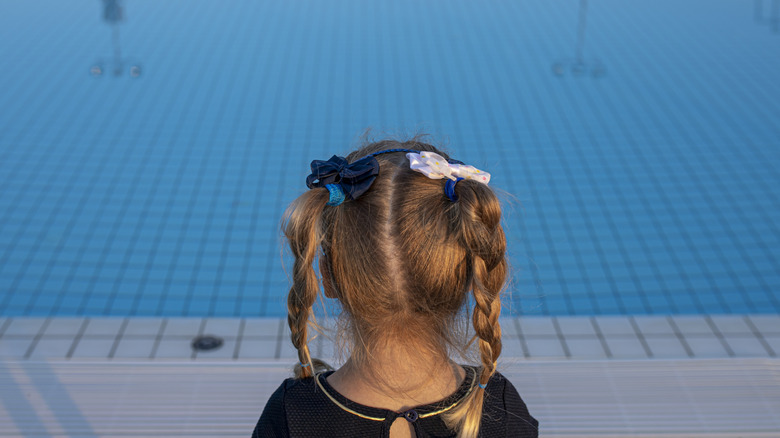 Child overlooking a swimming pool