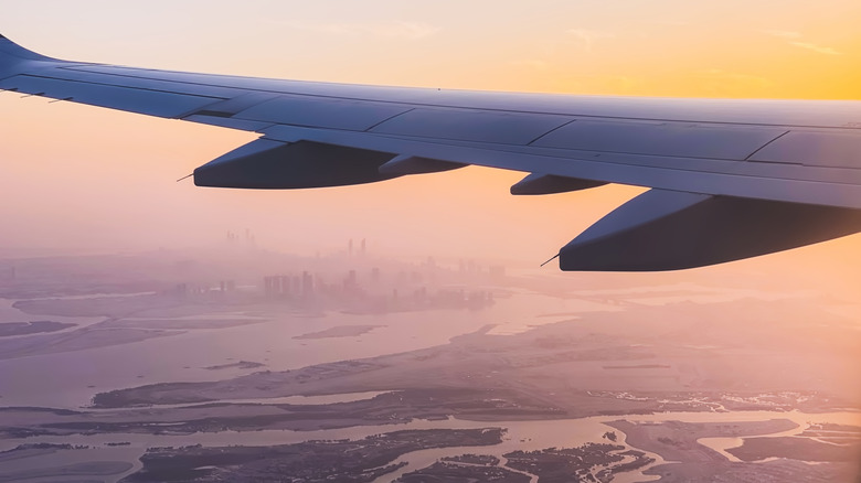 plane wing high above a foggy city