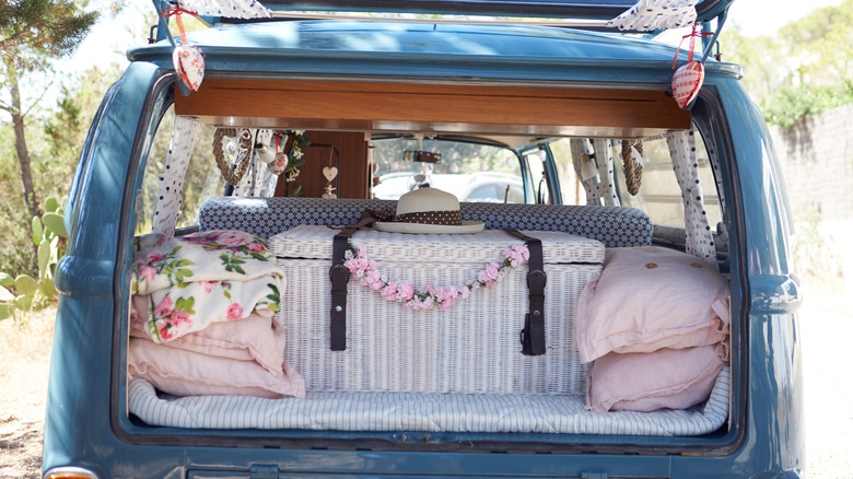 Open back of a retro camper van with luggage and cushions