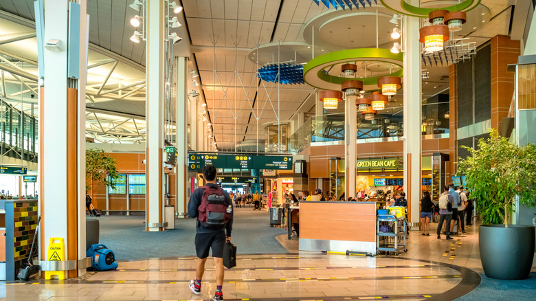 A man walking through an airport terminal.