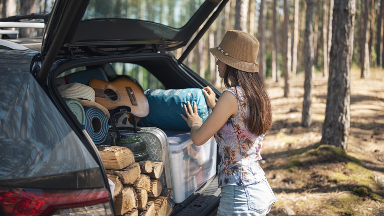 Woman unloading camping gear from a car