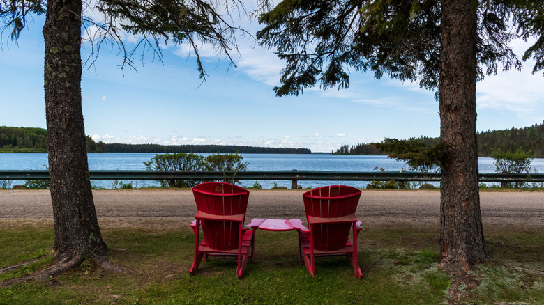 a pair of Adirondack chairs overlooking Clear Lake in Riding Mountain National Park