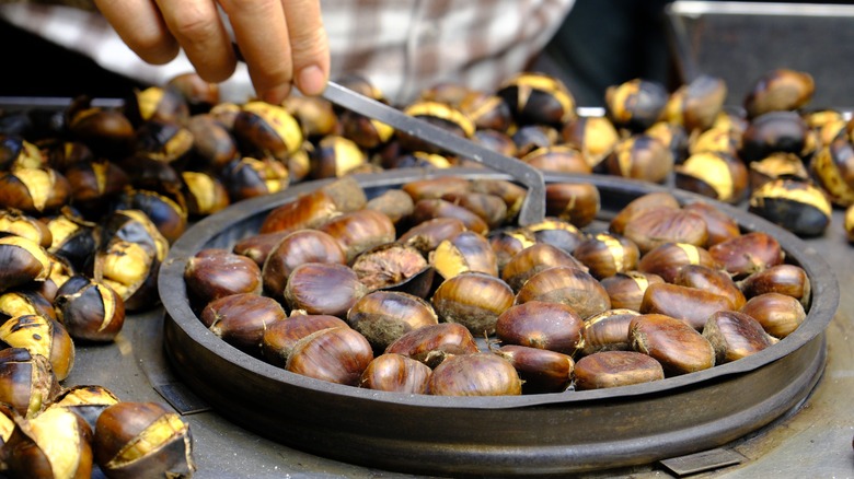 Up-close view of chesnuts roasting in a large pan