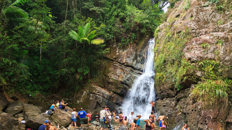 Tourists relax around a waterfall in Puerto Rico