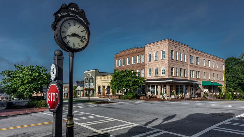 A photo showing downtown Senoia with its buildings, vintage clock, and stop sign