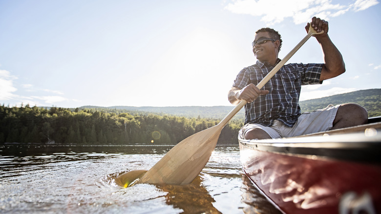 A man happily paddles on a lake