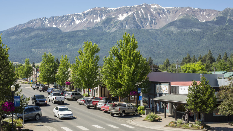 street with buildings, trees, mountains in background