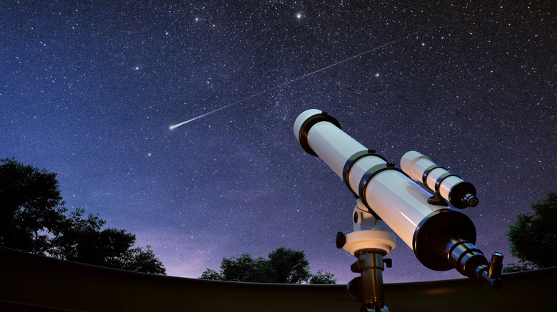 A shooting star darts across the sky with a telescope in frame