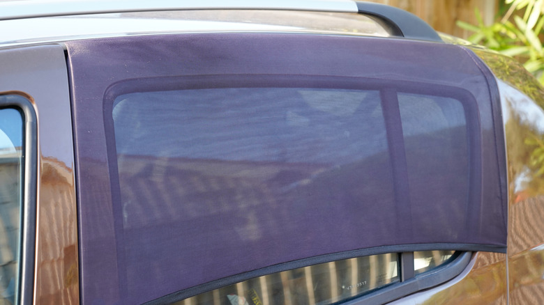 car window with black fabric shade screen