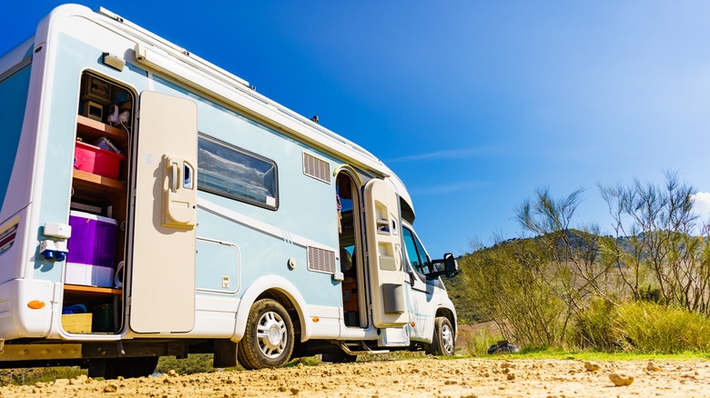 A well organized RV is parked on the edge of a desert