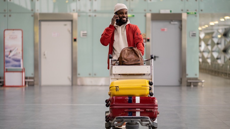Man using an airport luggage cart