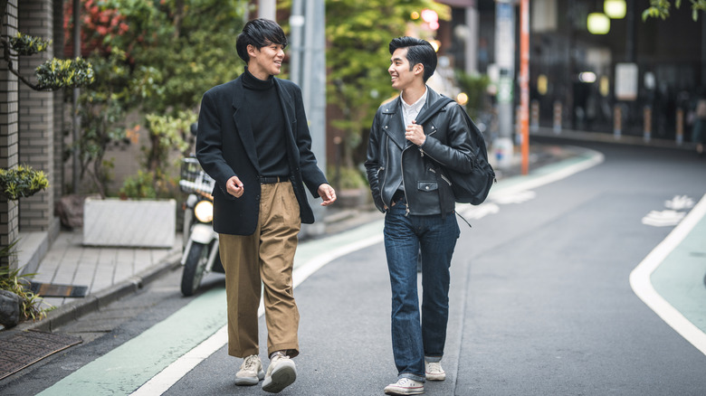 Two young Japanese men in neat casual walk down the street