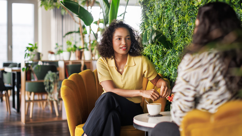 Two women talk at a café table
