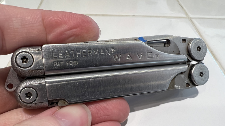 Someone holds a Leatherman multitool