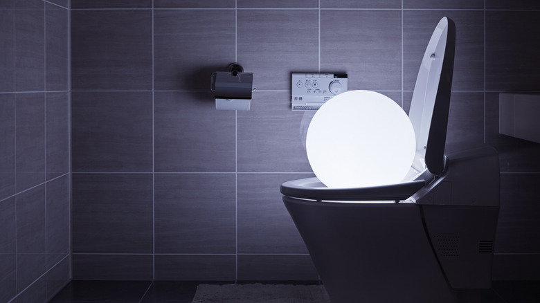Glowing ball sitting on top of a high-tech Japanese toilet