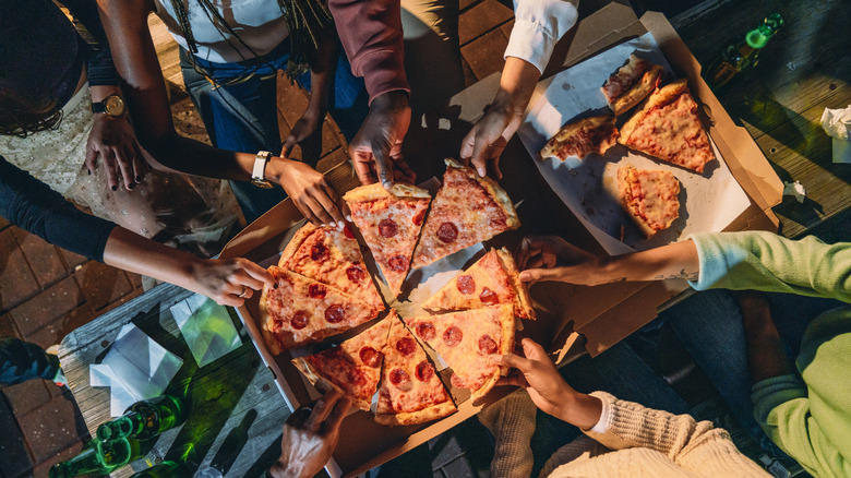 A group of friends enjoy pizza together
