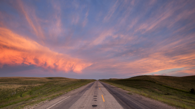 Road through prairies at sunset