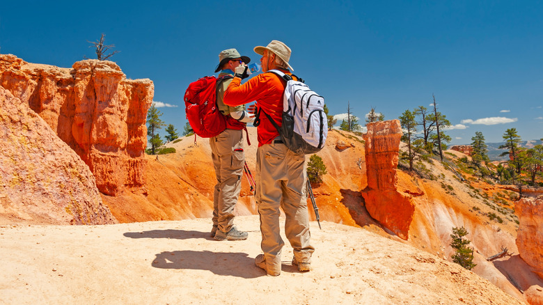 Two men standing among orange rock formations