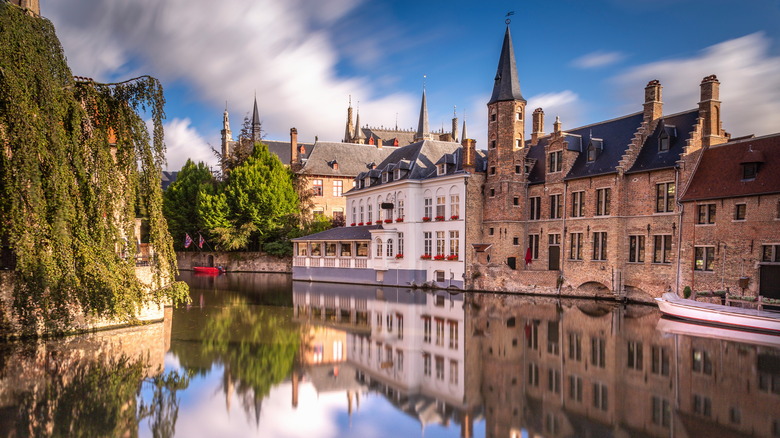 Historic buildings line a waterfront in Bruges, Belgium