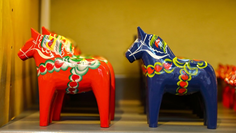 blue and red Dala horses standing on a shelf