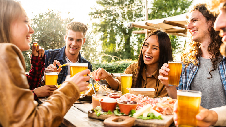 Patrons at a German restaurant toast with beers.