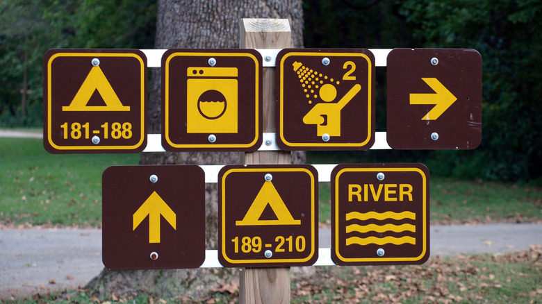 Signs with directions to campgrounds, laundry, river, and showers in a campsite
