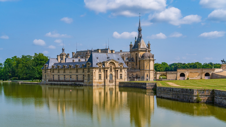 the rennaissance style Chateau de Chantilly surrounded by a moat and parkland