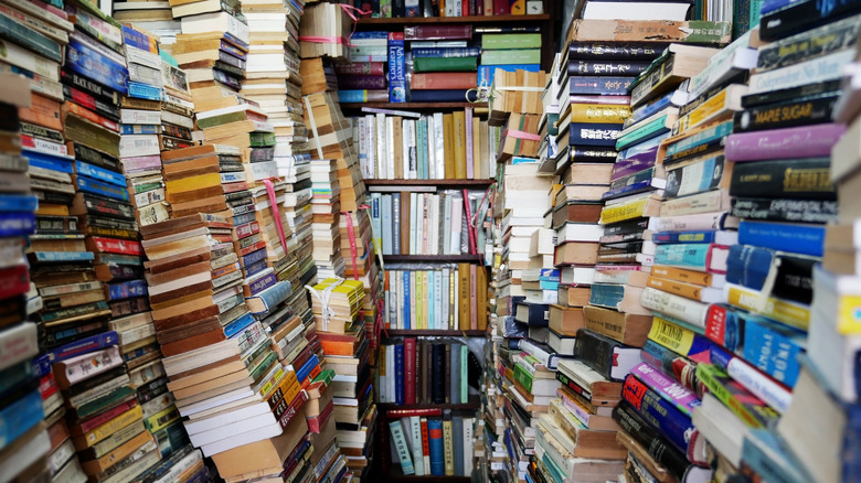A thin aisle with books stacked from the floor to the ceiling