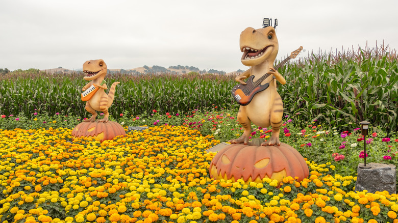 Small T-Rex sculptures play electric guitar at Spina Farms