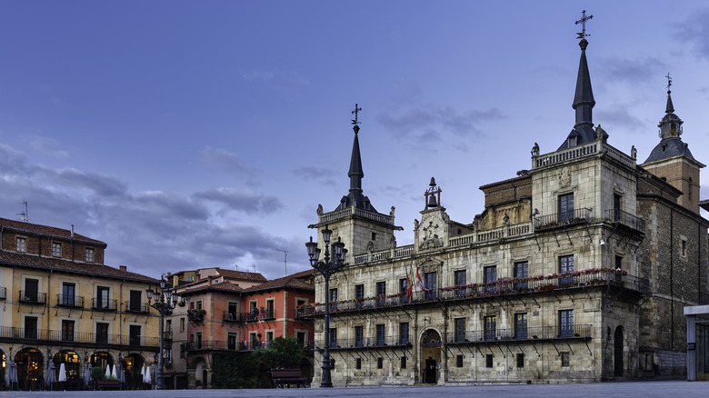 An old town square in Europe with city hall and restaurants lining the square at dusk