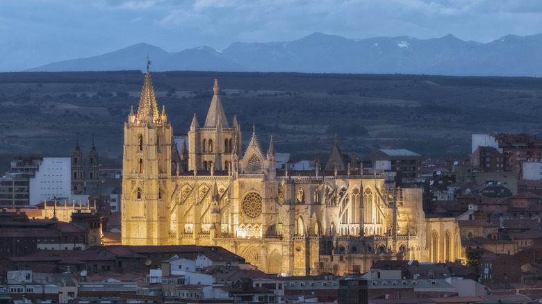 A massive Gothic Cathedral lit up at dusk taken from a distance