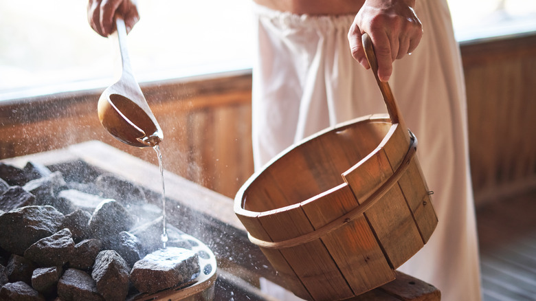 Man adding water to a Finnish sauna