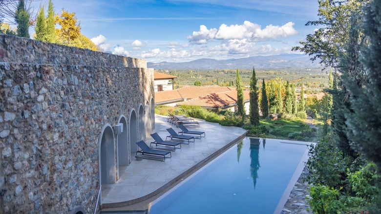 Large pool overlooking a valley with a stone wall on one side