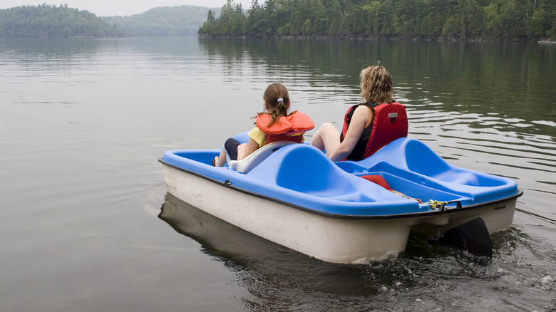Two people paddle boating on a lagoon