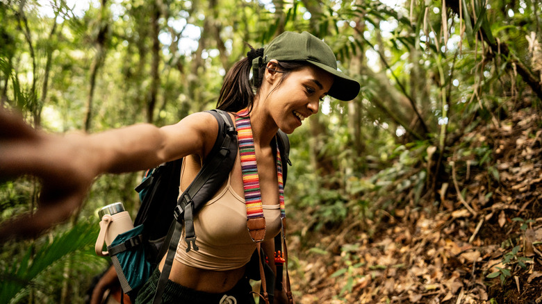Young tourist woman doing hiking on forest